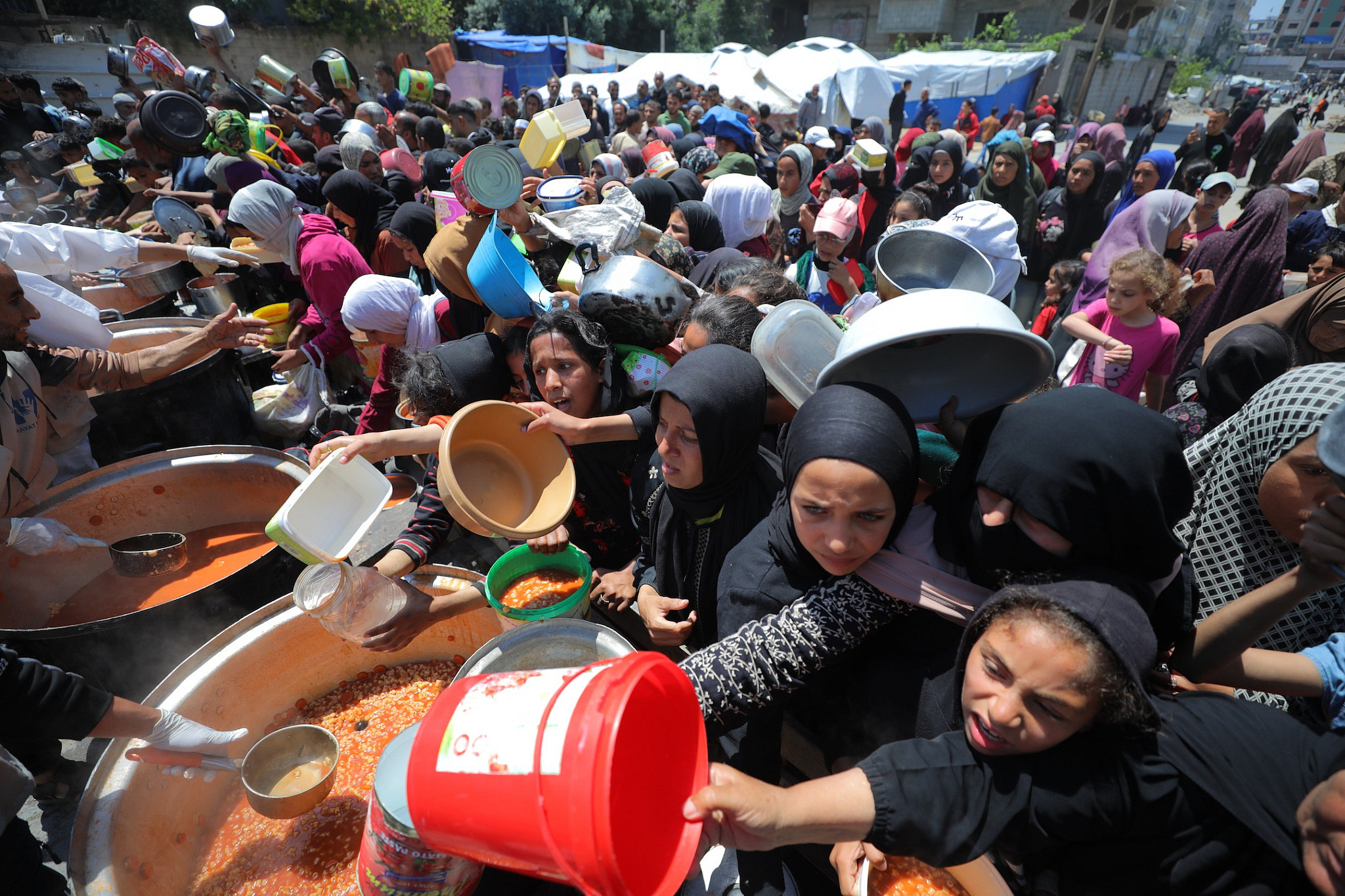 Des Palestiniens déplacés font la queue pour recevoir un repas dans le nord de la bande de Gaza, le 5 mai 2025. (Ali Hassan/Flash90)